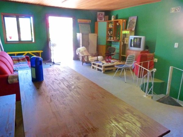 Ao lado da cozinha, há uma sala de estar ampla e e uma área aberta com cadeiras
